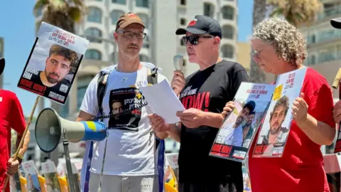 Former hostage Keith Siegel speaks at a rally held by hostages' families on the beachfront near the US embassy branch office in Tel Aviv, Israel