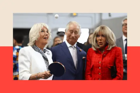alt=AFP via Getty Images Queen Camilla plays table tennis, next to King Charles III and Brigitte Macron, during a visit to the Saint-Denis, a northern suburb of Paris, on 21 September 2023.