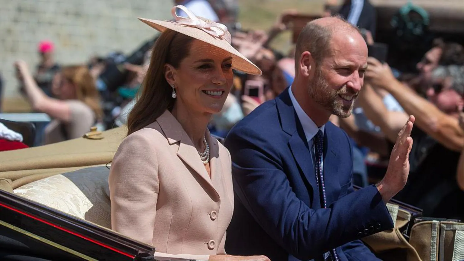 Anadolu via Getty Images Princess of Wales Catherine and Prince of Wales William wave to crowds as they sit in a carriage.