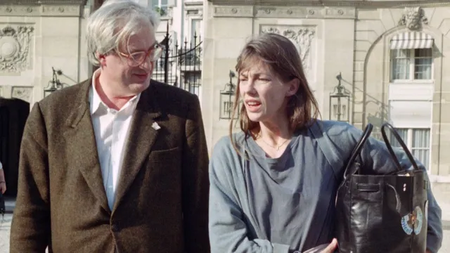 Jane Birkin is pictured walking and talking with French director Bertrand Tavernier, carrying the iconic bag.