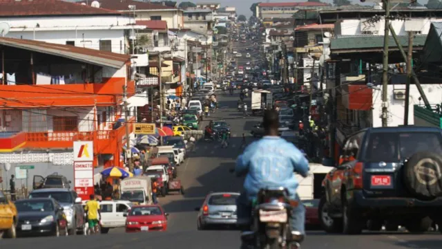 A view of a busy street in Monrovia with many cars and shops