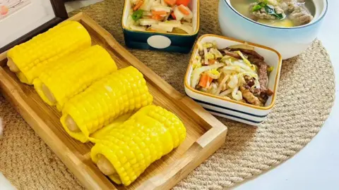 Bright yellow corn rolls and stir-fried vegetables served at a Chinese pre-school.