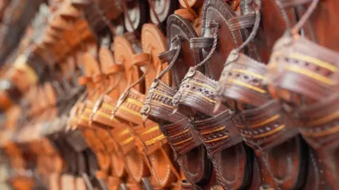 Kolhapuri sandals in various shades of brown displayed at a shop.