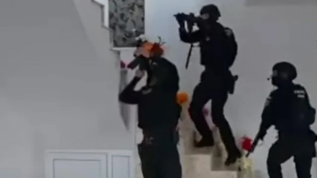 Armed police officers seen ascending stairs during raids connected to the tax scam.