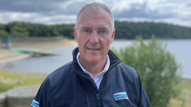Dave Kaye, Yorkshire Water representative, standing in front of a reservoir.