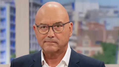Gregg Wallace, presenter of MasterChef, in a dark suit.