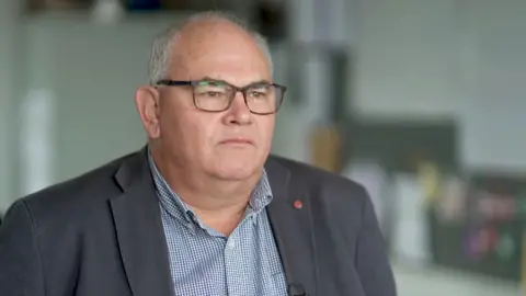 Paul Abbott, a director from KNP, with glasses and a blazer.
