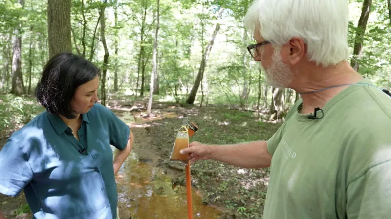 Gordon Rogers showing a water sample to the BBC’s Michelle Fleury