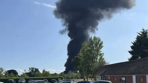 Thick dark smoke billowing into the sky from an incident at Southend Airport.