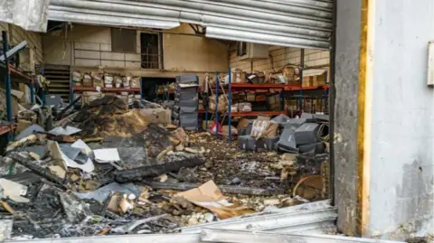 An image showing the burnt-out interior of a warehouse unit.
