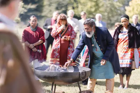 Delegates gather around a fire at the Harmony Summit in Highgrove.