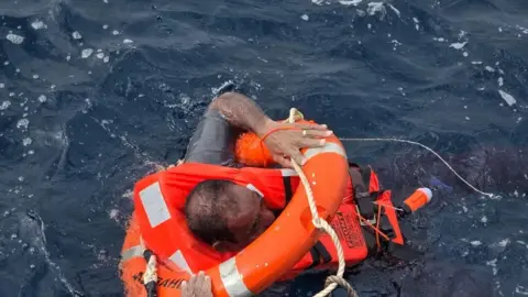 A crew member from the cargo ship Eternity C is seen in the Red Sea during a rescue operation.