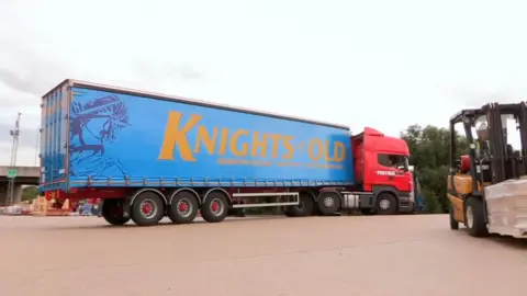 A 'Knights of Old' lorry parked on a concrete surface. The trailer has a knight on horseback.