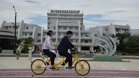 Domestic tourists ride a bicycle at Wonsan Kalma Coastal Tourist Area