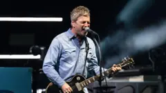 Noel Gallagher playing guitar