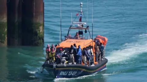 A group of people, believed to be migrants, being brought ashore to Dover, Kent, by an RNLI lifeboat.
