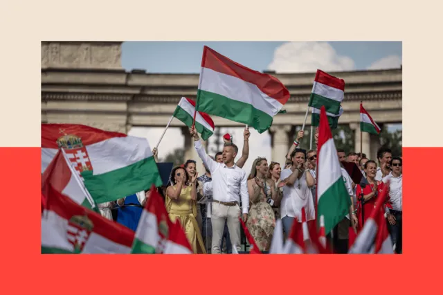 Peter Magyar addressing a large crowd at a political rally, holding the Hungarian flag.